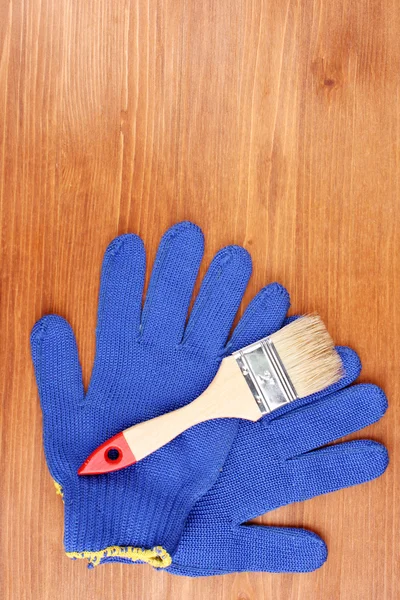 Pensel och handskar på trä bakgrund — Stockfoto