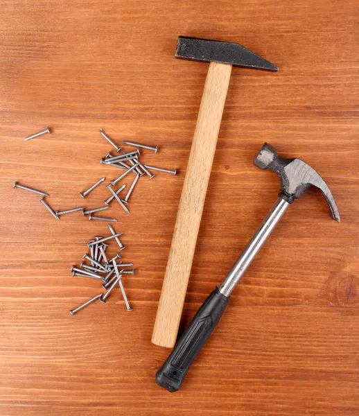 Hammers and metal nails on wooden background — Stock Photo, Image