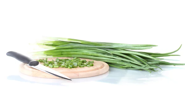 Groene ui op een snijplank met mes geïsoleerd op wit — Stockfoto