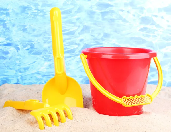 Children's beach toys on sand on water background — Stock Photo, Image