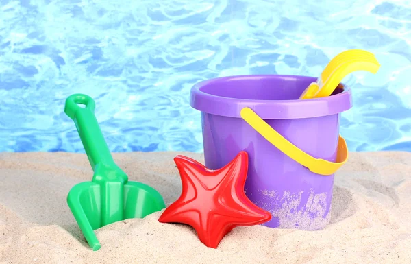 Anak-anak pantai mainan di pasir di latar belakang air — Stok Foto