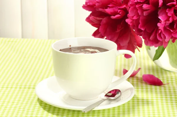 Cup hot chocolate and flowers on table in cafe — Stock Photo, Image