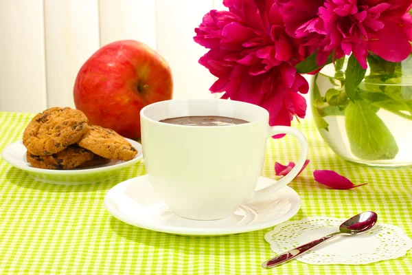 Cup hot chocolate, apple, cookies and flowers on table in cafe — Stock Photo, Image