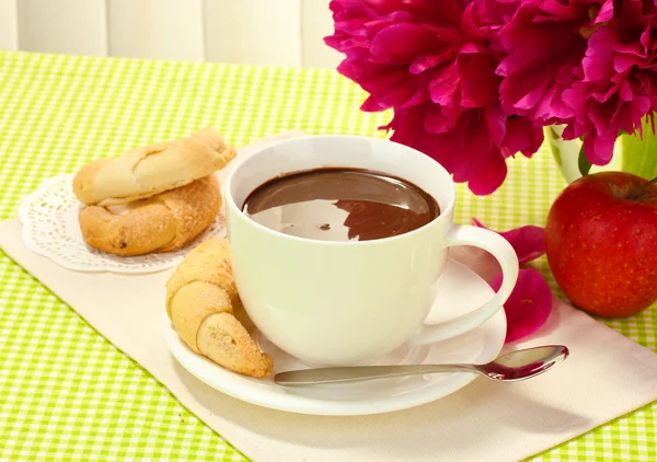 Taza de chocolate caliente, manzana, galletas y flores en la mesa en la cafetería —  Fotos de Stock