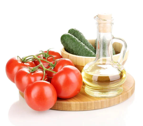 Tomatoes and cucumbers with oil on wooden board isolated on white — Stock Photo, Image