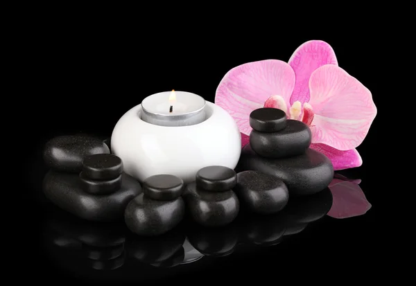 Spa kamienie z orchidea kwiat i świeca na czarnym tle — Zdjęcie stockowe