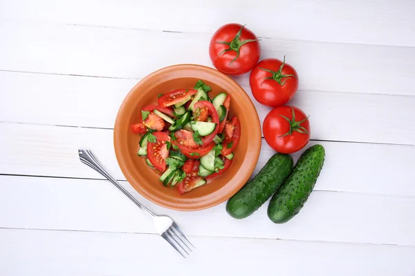 Świeże sałatki z pomidorów i ogórków na białym tle drewniane — Zdjęcie stockowe