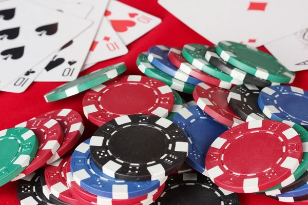 Красный покерный стол с игральными картами и фишками для покера — стоковое фото