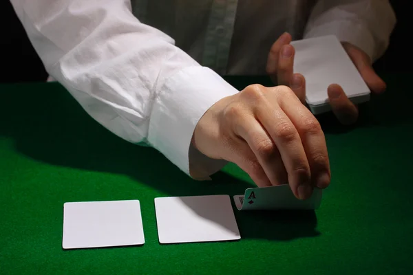 Karty v rukou na zeleném stole — Stock fotografie