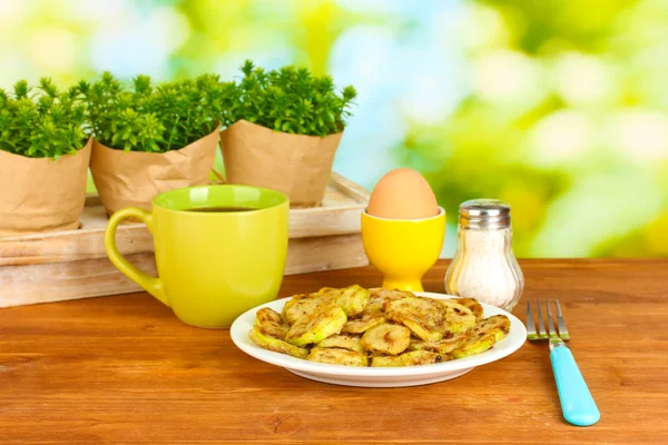 Smażone cukinia z jaj i kawa na śniadanie na drewnianym stole na zielonym tle — Zdjęcie stockowe
