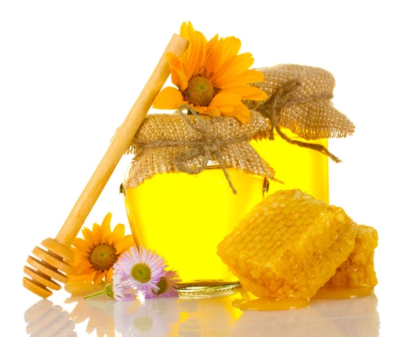 Süßer Honig in Gläsern mit Waben, hölzernem Nieselregen und Blüten isoliert auf weiß — Stockfoto