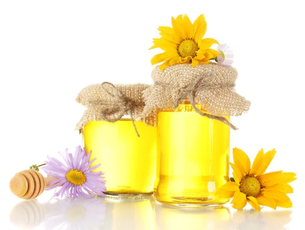 Zoete honing in potten met houten drizzler en bloemen geïsoleerd op wit — Stockfoto