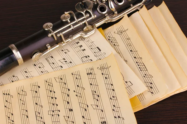 Музичні ноти і кларнет на дерев'яному столі — стокове фото