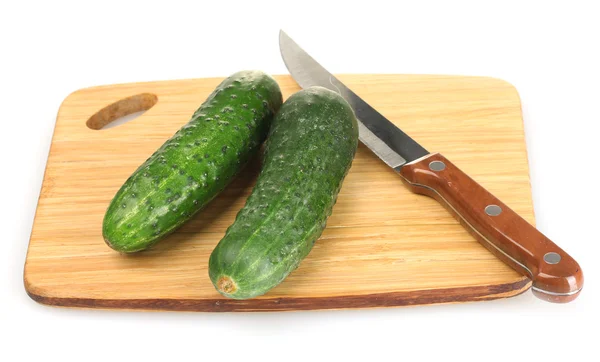 Fresh cucumbers and knife on cutting board isolated on white — Stock Photo, Image