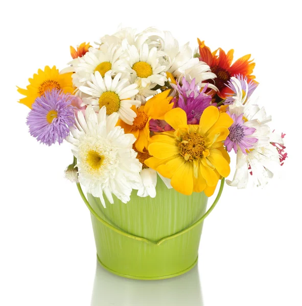 Beautiful bouquet of bright wildflowers in green metal bucket, on wooden table on blue background — Stock Photo, Image