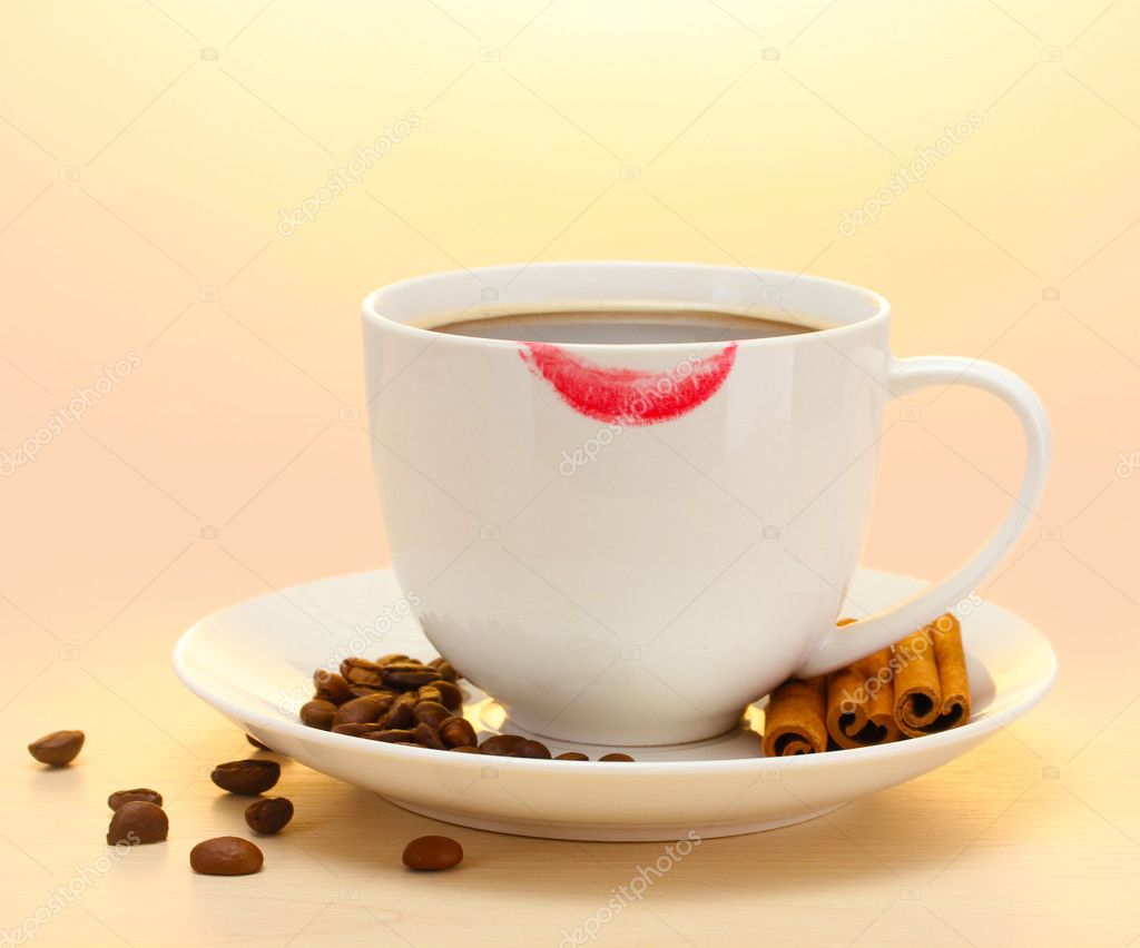 Tazza di caffè con fagioli marcati con rossetto e bastoncini di cannella  sul tavolo di legno - Foto Stock: Foto, Immagini © belchonock 11071276