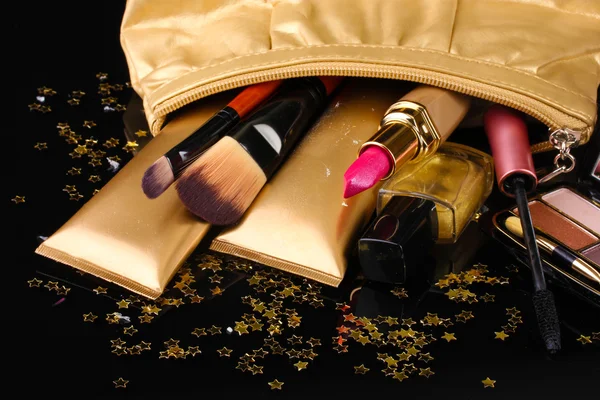 Bella borsa trucco dorato e cosmetici isolati su nero — Foto Stock