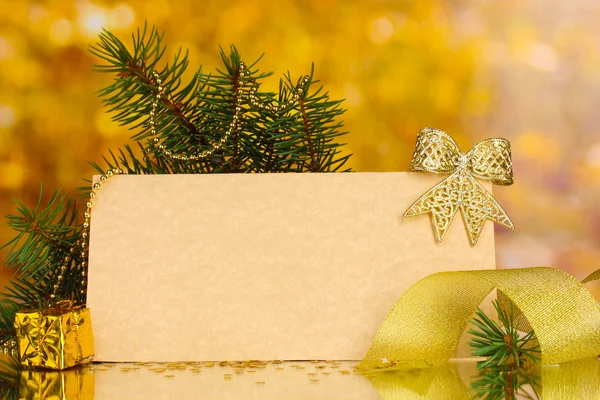 Cartolina bianca, palline di Natale e abete su sfondo giallo — Foto Stock