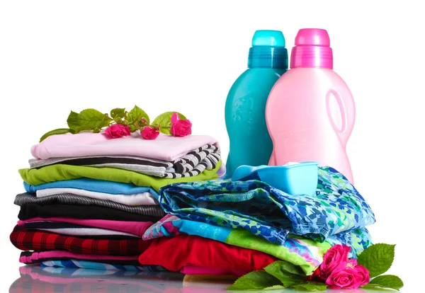 Vaskemiddel med vaskepulver og bunke af farverigt tøj isoleret på hvidt - Stock-foto