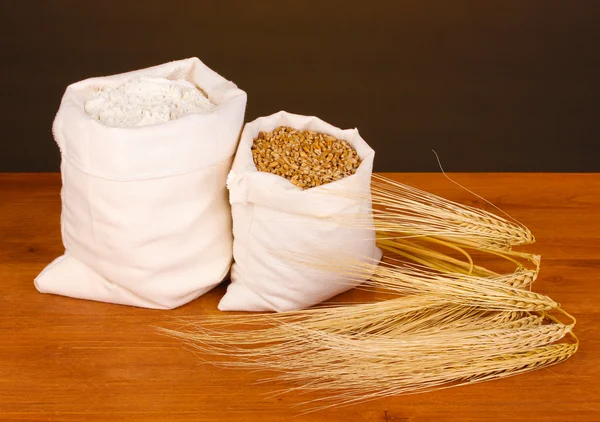 Un ve buğday tahıl koyu arka plan üzerinde ahşap tablo — Stok fotoğraf