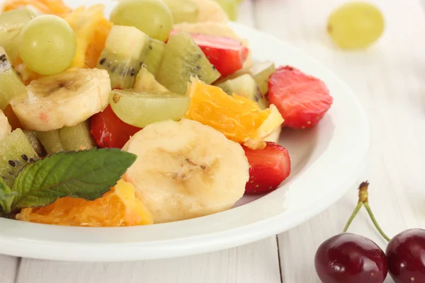 プレートと白の木製テーブル上の果実のフレッシュ フルーツのサラダ — ストック写真