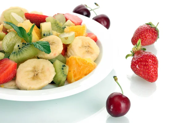 Fresh fruits salad on plate and berries isolated on white — Stock Photo, Image