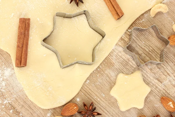 Latas de biscoitos na massa de farinha estendida com ervas em um close-up de mesa de madeira — Fotografia de Stock