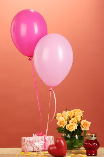 Romantyczny prezent dziewczyna. kolorowe balony gospodarstwa prezent na czerwonym tle — Zdjęcie stockowe