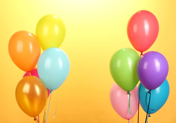 Kleurrijke ballonnen op gele achtergrond close-up — Stockfoto