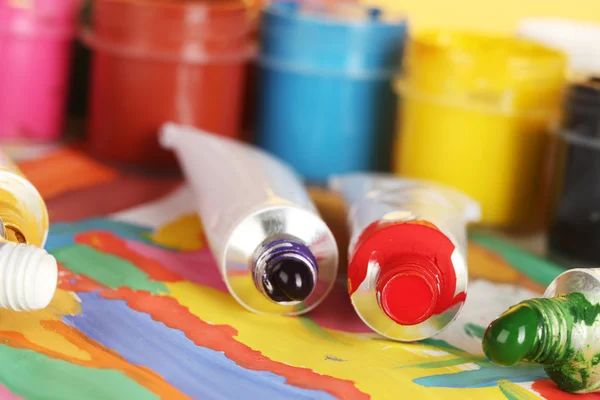 Tubes avec aquarelle colorée et pots avec gouache sur image colorée close-up — Photo