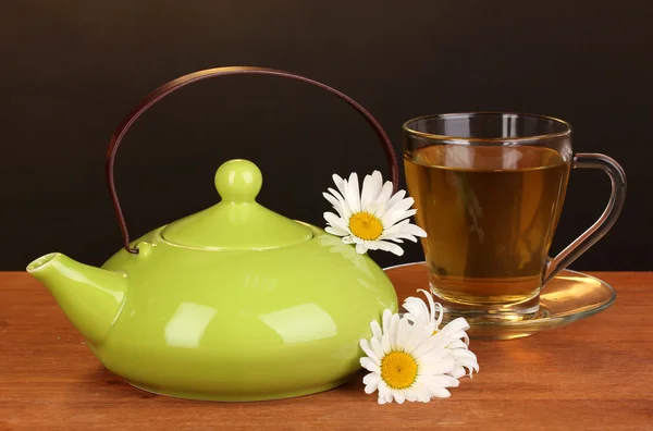 茶壶和洋甘菊茶棕色背景上的木桌上的杯子 — 图库照片