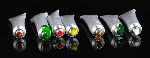 Tubes with a bright colorful watercolor isolated on black background close-up — Stock Photo, Image
