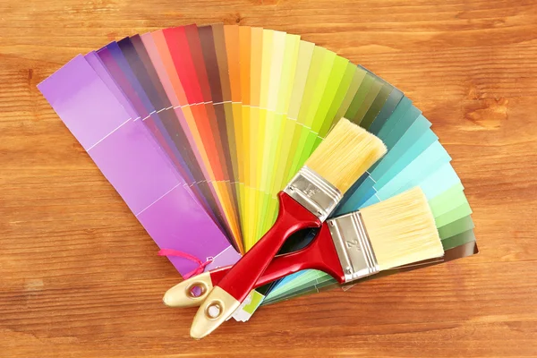 Pinceaux et palette de couleurs vives sur fond en bois — Photo