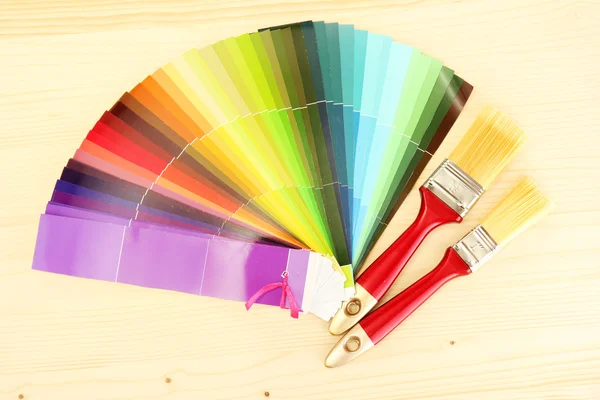 Пензлі фарби і яскрава палітра кольорів на дерев'яному фоні — стокове фото