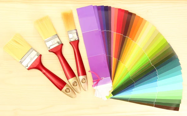 Boya fırçaları ve renk ahşap zemin üzerinde parlak paleti — Stok fotoğraf