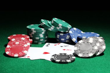 Cards and chips for poker on green table clipart