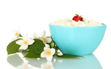 Cottage cheese with strawberry in blue bowl and flowers isolated on white clipart