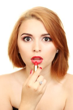 Beautiful woman is applying her lips with red lipstick clipart