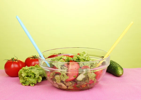 Свежий салат с помидорами и огурцами на зеленом фоне — стоковое фото