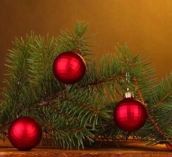 Новорічна ялинка з красивими новорічними кульками на дерев'яному столі на коричневому фоні — стокове фото