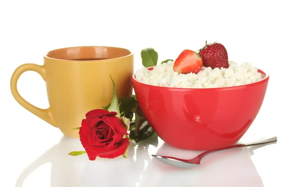 Τυρί cottage με φράουλας στην κόκκινο μπολ και πορτοκαλί Κύπελλο με τον καφέ, κουτάλι και λουλουδιών που απομονώνονται σε λευκό — Φωτογραφία Αρχείου