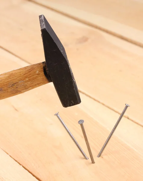 Pregos de metal em prancha de madeira e martelo — Fotografia de Stock