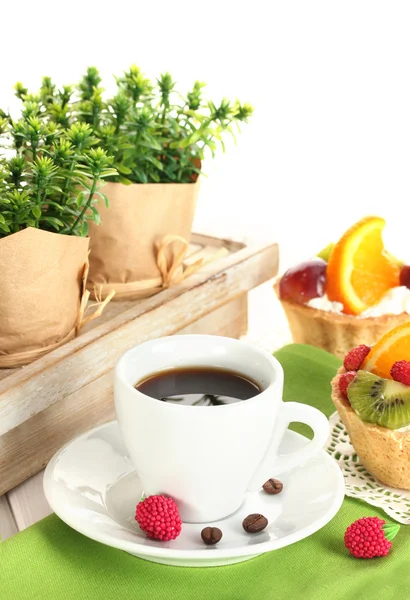 Šálek kávy a sladké koláče s ovocem na dřevěný stůl — Stock fotografie