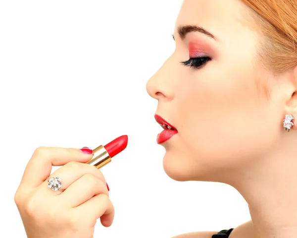 Mooie vrouw is het aanbrengen van haar lippen met rode lippenstift — Stockfoto