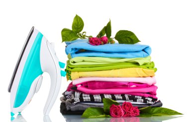 Pile of colorful clothes and electric iron with roses isolated on white clipart