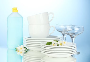 boş temiz tabak, bardak ve bulaşık deterjanı ve mavi zemin üzerine sünger ile gözlük