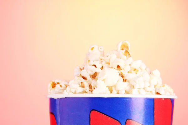 Bucket with popcorn on orange — Stock Photo, Image