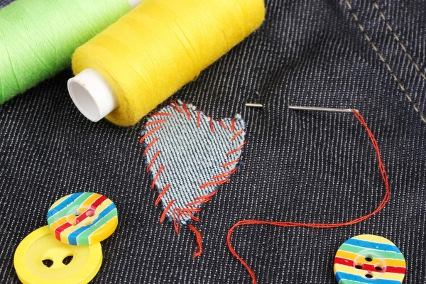 Parche en forma de corazón en jeans con hilos y botones de primer plano —  Fotos de Stock