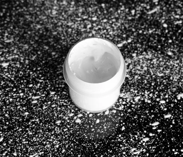 白いペンキのクローズ アップが跳ね掛かって、黒い背景に白のグワッシュと jar します。 — ストック写真