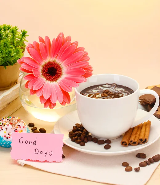 Tasse Kaffee und Gerberabohnen, Zimtstangen auf Holztisch — Stockfoto